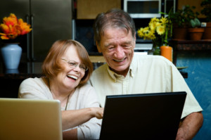 Senior couple using laptop computers at home